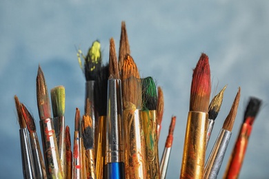 Different paint brushes on light background, closeup