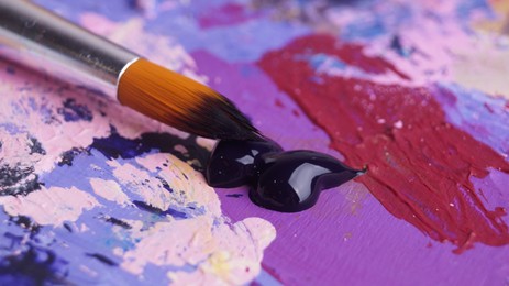 Photo of Artist's palette with mixed paints and brush, closeup