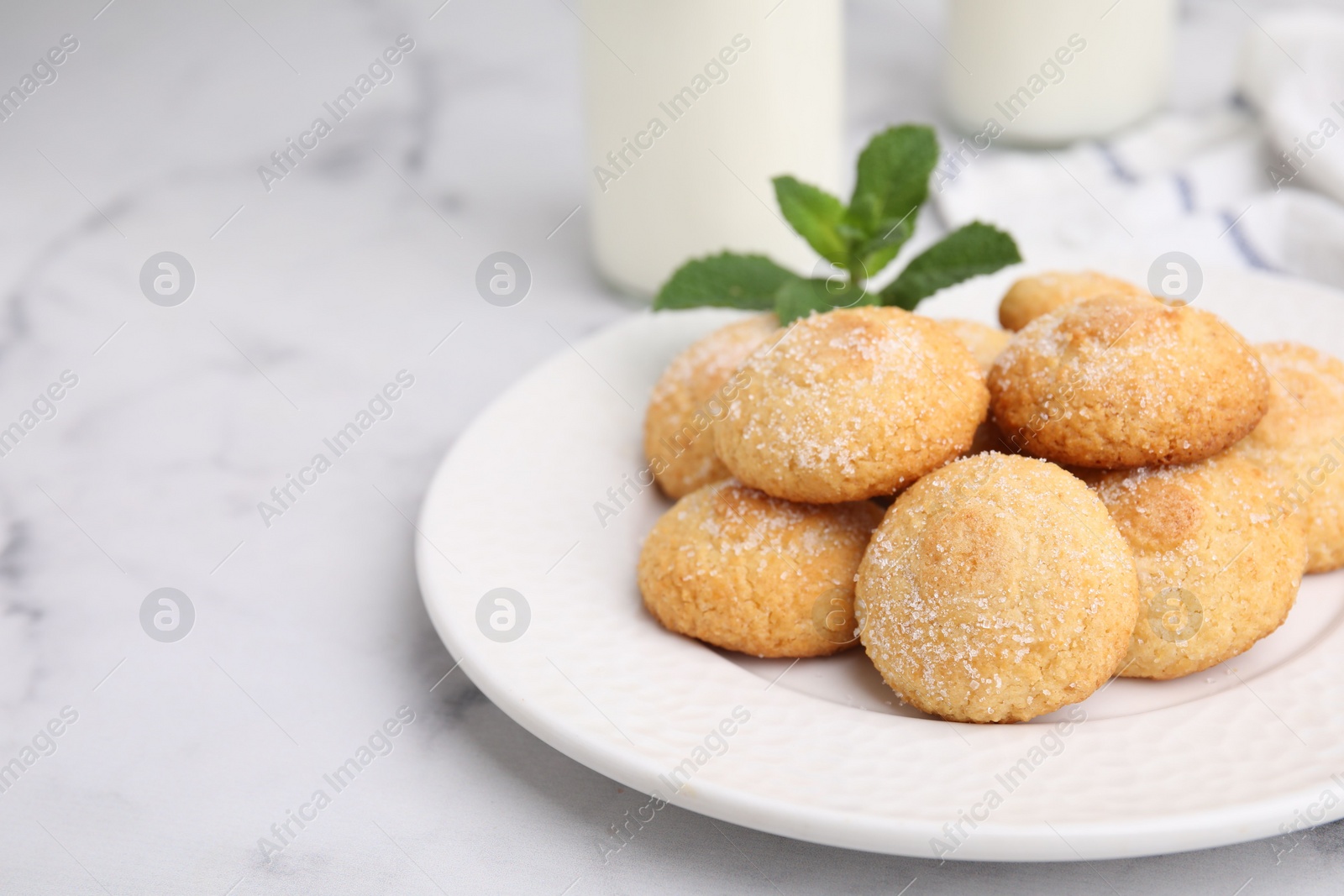 Photo of Tasty sweet sugar cookies on white marble table, closeup. Space for text