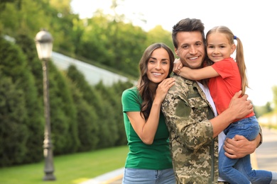 Man in military uniform with his family  at sunny park