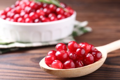 Photo of Fresh ripe cranberries on wooden table, closeup