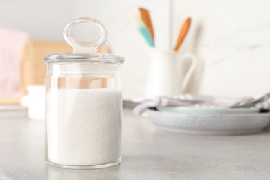 Photo of Jar with white sugar on grey table