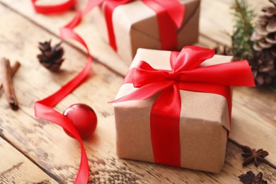 Photo of Christmas gift box and decor on wooden table, closeup