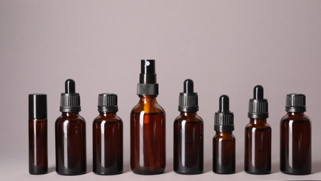 Photo of Cosmetic bottles of essential oils on color background