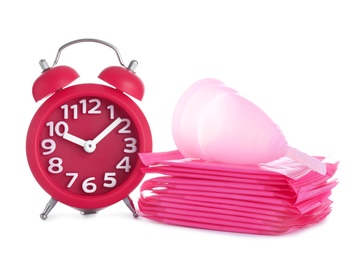 Photo of Clock, menstrual pads and cup on white background. Gynecology concept