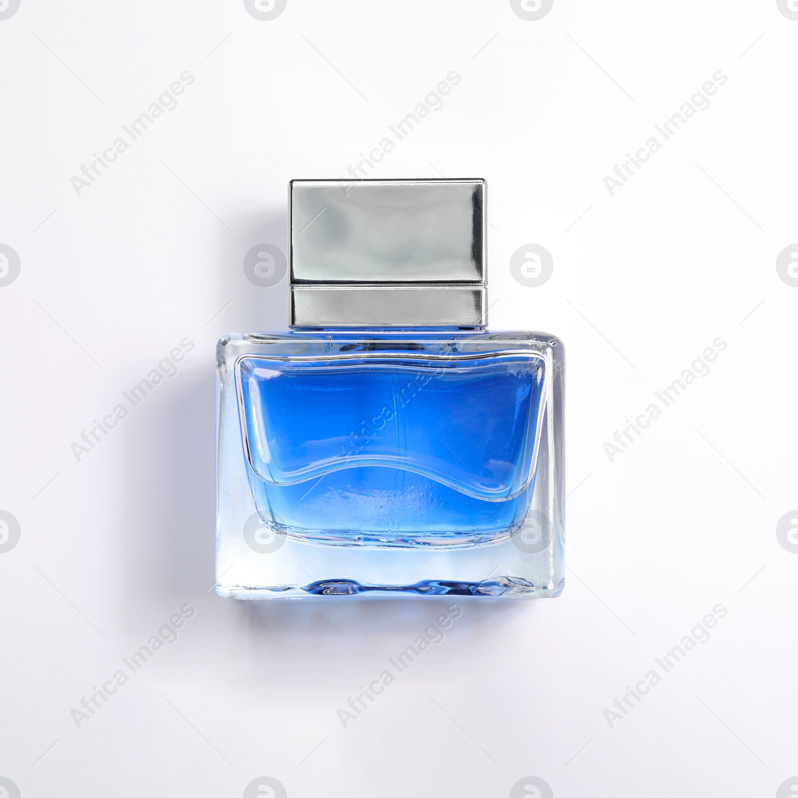 Photo of Blue men's perfume in bottle on white background, top view