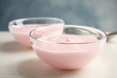 Glass bowl with creamy yogurt on table