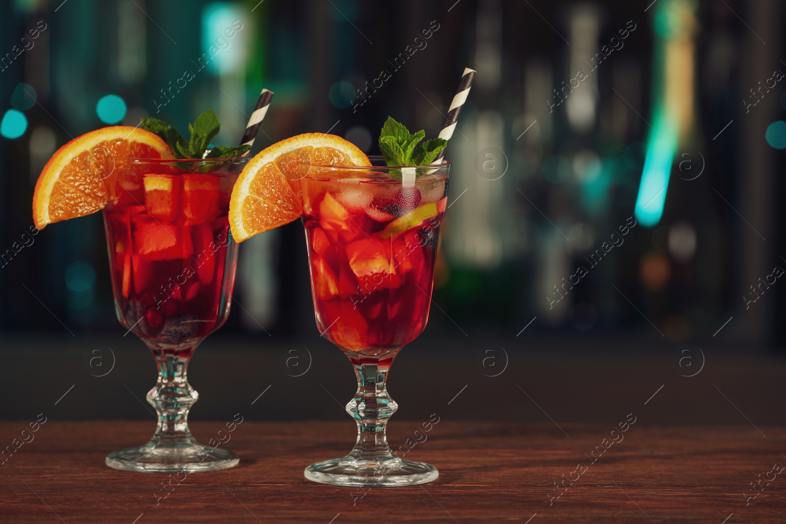 Photo of Delicious sangria cocktail on wooden table in bar. Space for text