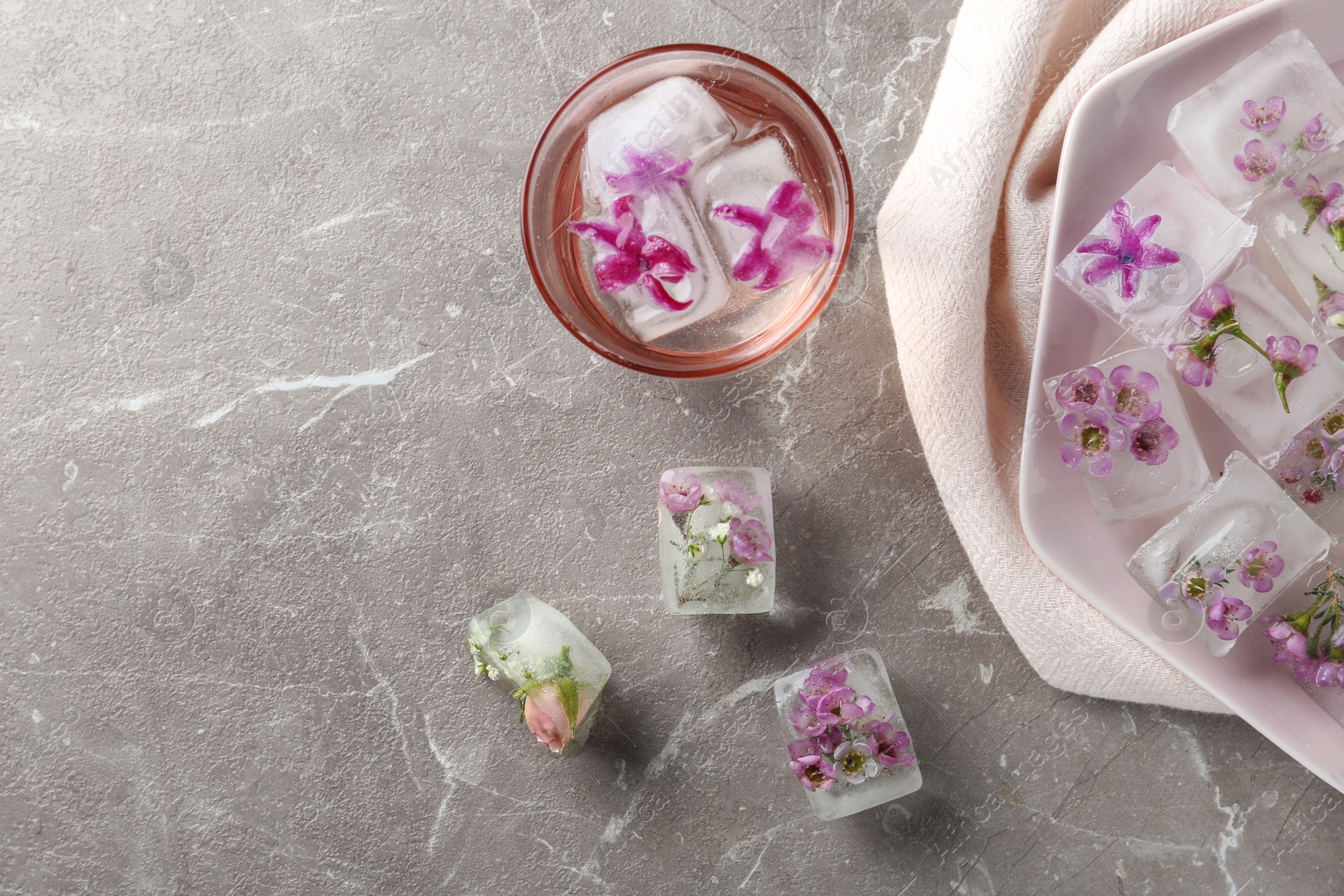 Photo of Flat lay composition with floral ice cubes on table. Space for text