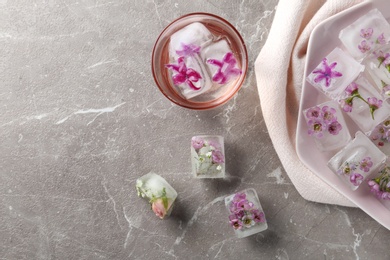 Photo of Flat lay composition with floral ice cubes on table. Space for text