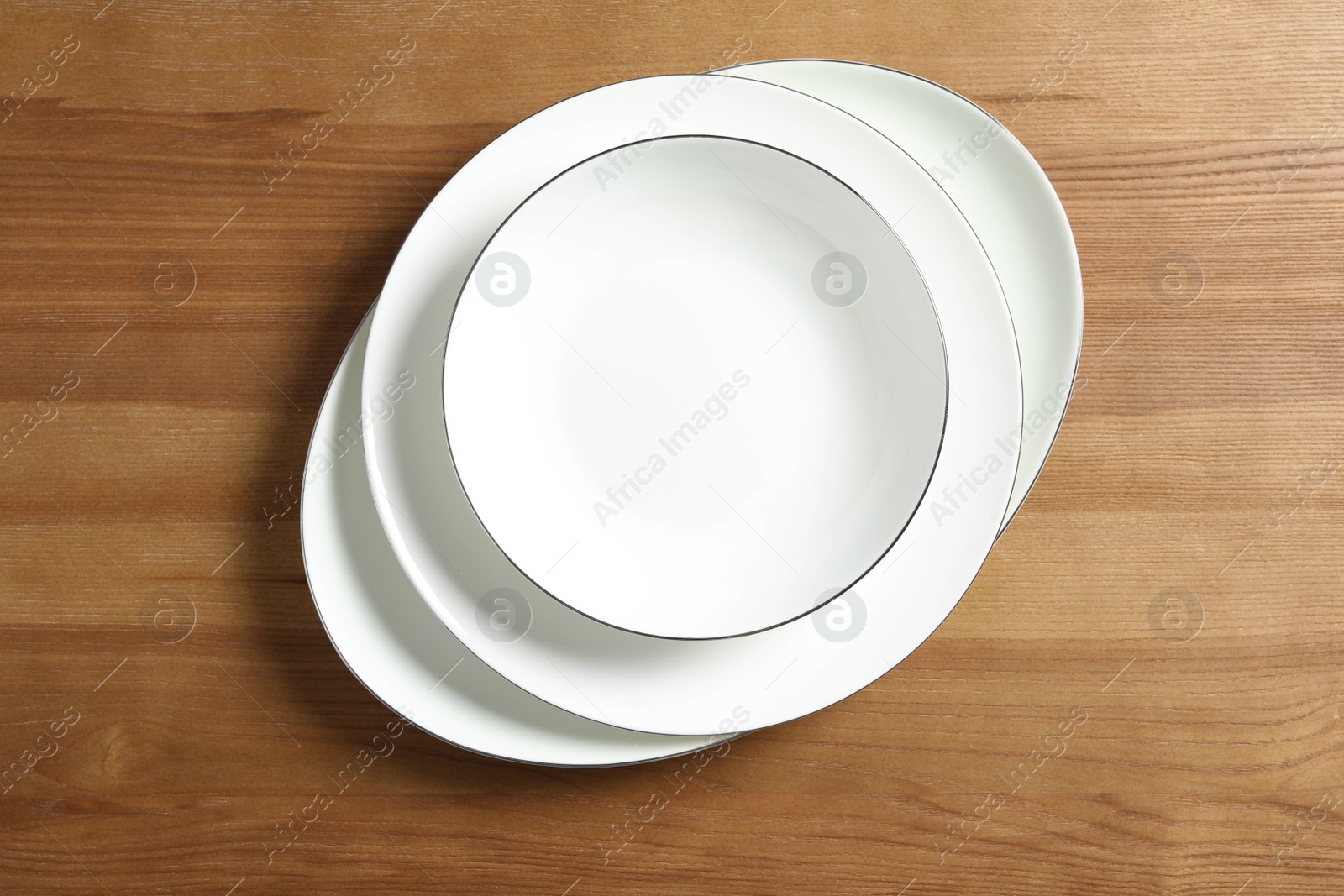 Photo of Stack of ceramic plates on wooden table, top view