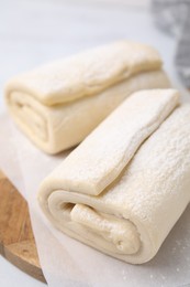 Photo of Raw puff pastry dough on table, closeup