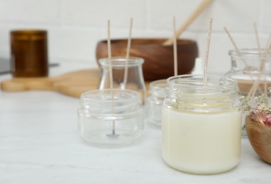 Photo of Glass jar with wax and wick on white table, space for text. Making homemade candle