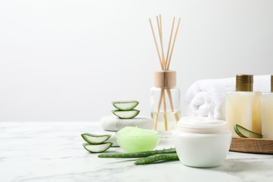 Photo of Different cosmetic products and aloe on white marble table. Space for text