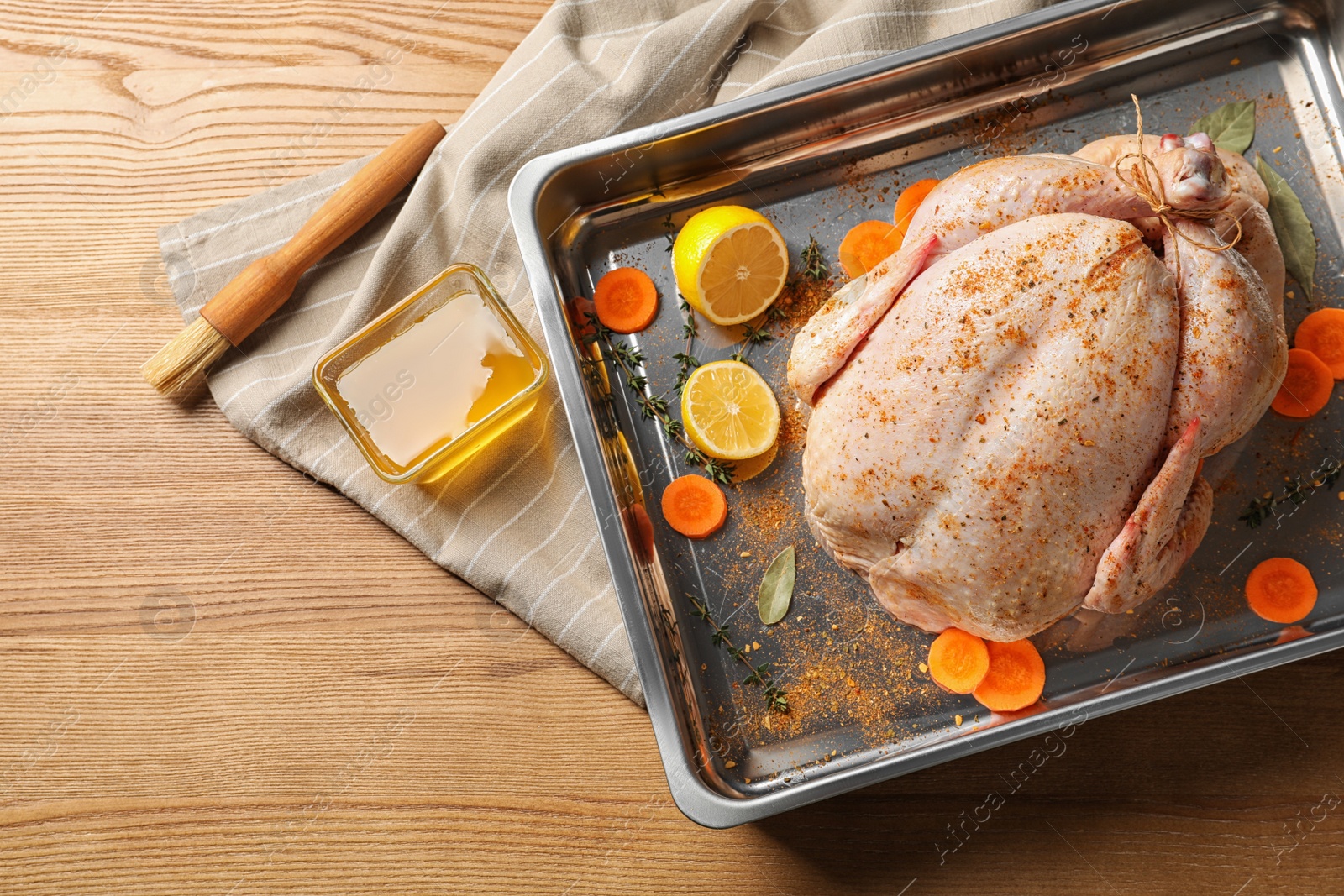 Photo of Dish with raw spiced turkey on wooden background, top view. Space for text