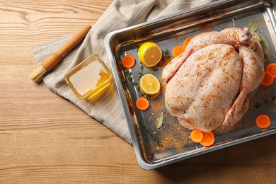 Photo of Dish with raw spiced turkey on wooden background, top view. Space for text