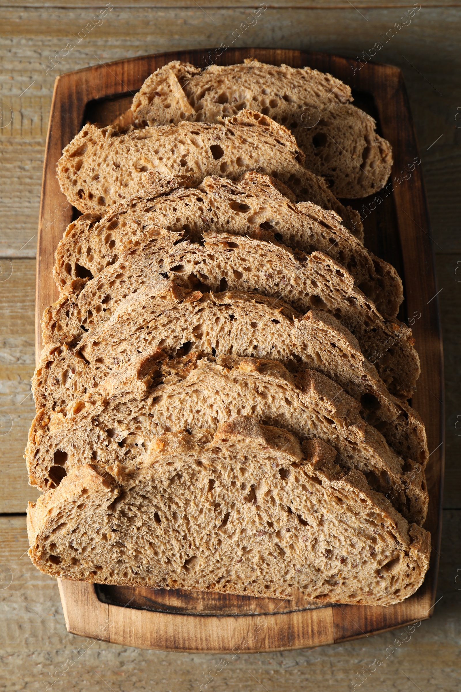 Photo of Freshly baked cut sourdough bread on wooden table, top view