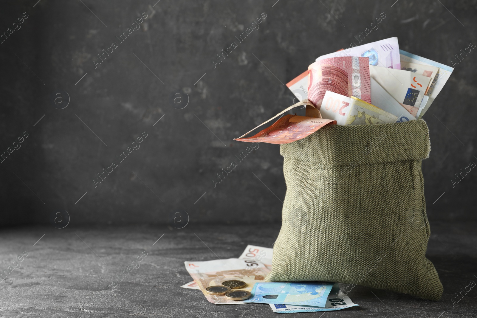 Image of Sack full of money on grey table. Space for text 