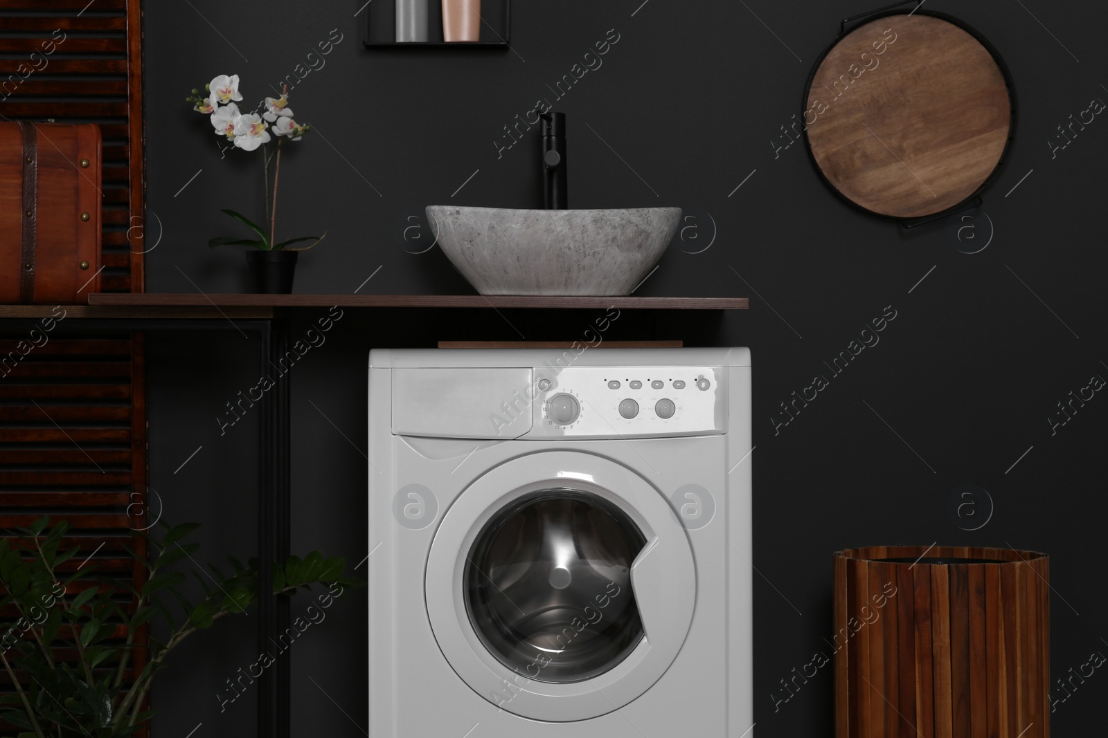 Photo of Stylish laundry room with washing machine. Interior design