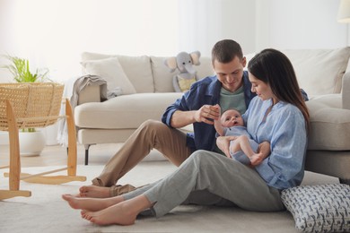 Happy family with cute baby near sofa at home