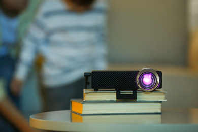 Photo of Video projector on wooden table at home. Space for text