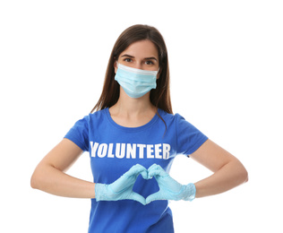 Photo of Female volunteer in protective mask and gloves showing heart gesture on white background. Aid during coronavirus quarantine