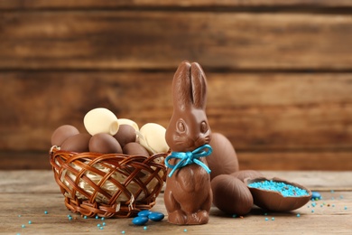 Chocolate Easter bunny with blue bow and eggs on wooden table