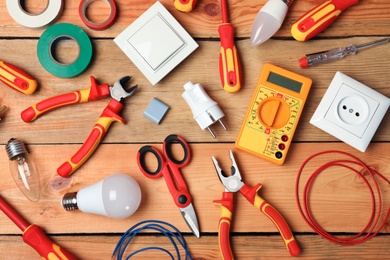 Photo of Flat lay composition with electrician's tools on wooden background