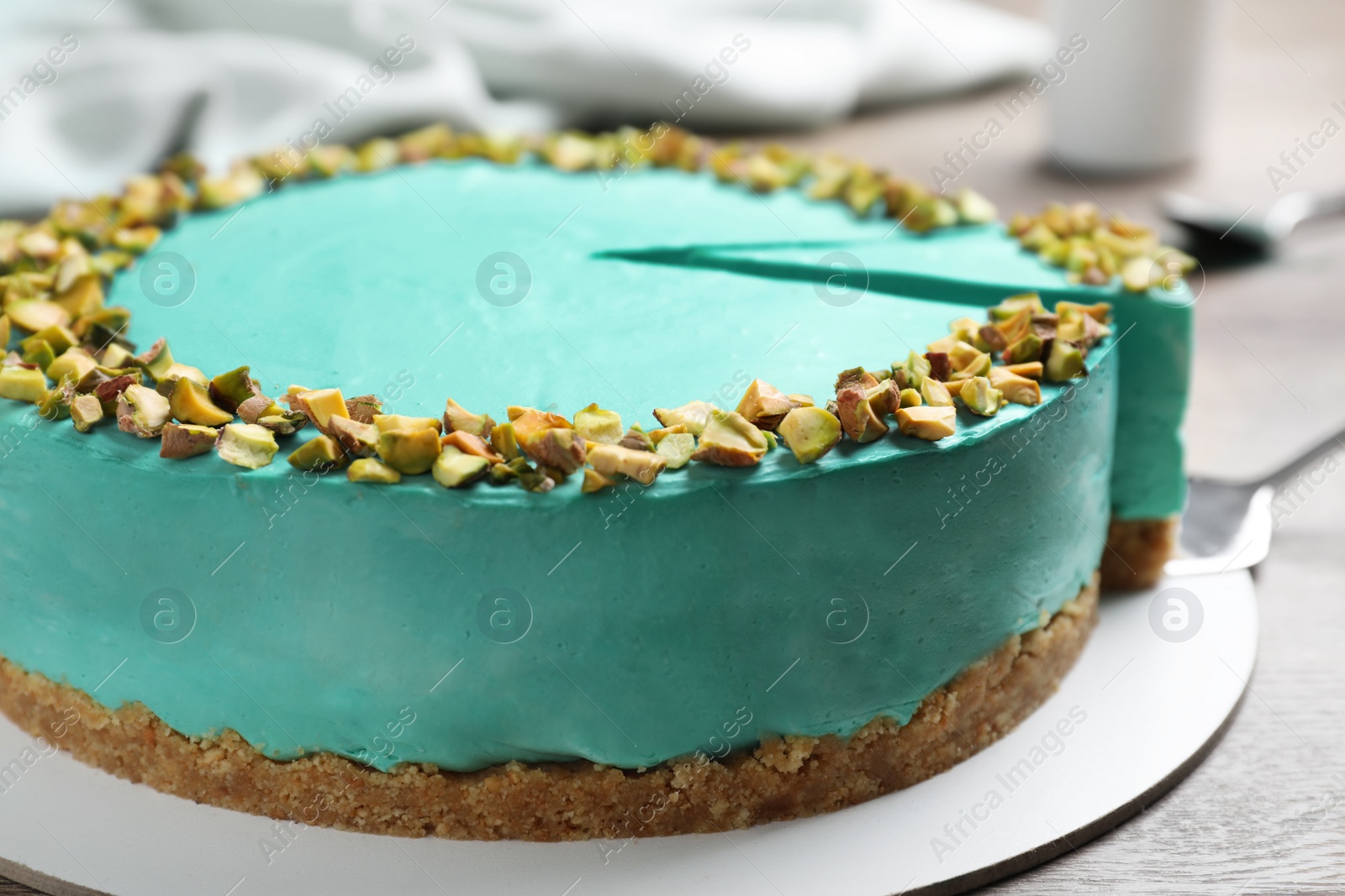 Photo of Tasty spirulina cheesecake on wooden table, closeup view