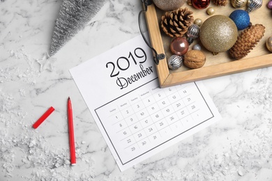 Photo of Flat lay composition with paper calendar on white marble table