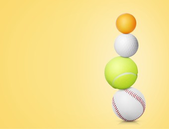 Image of Stack of different sport balls on light yellow background, space for text