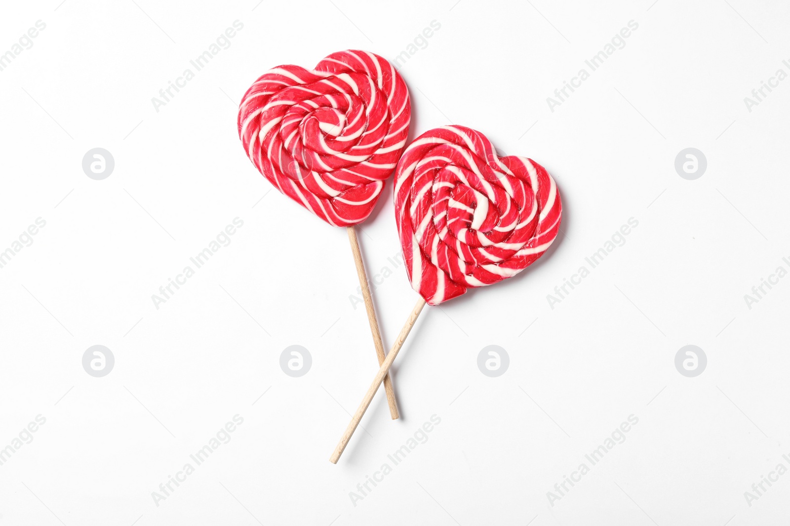 Photo of Sweet heart shaped lollipops on white background, flat lay. Valentine's day celebration