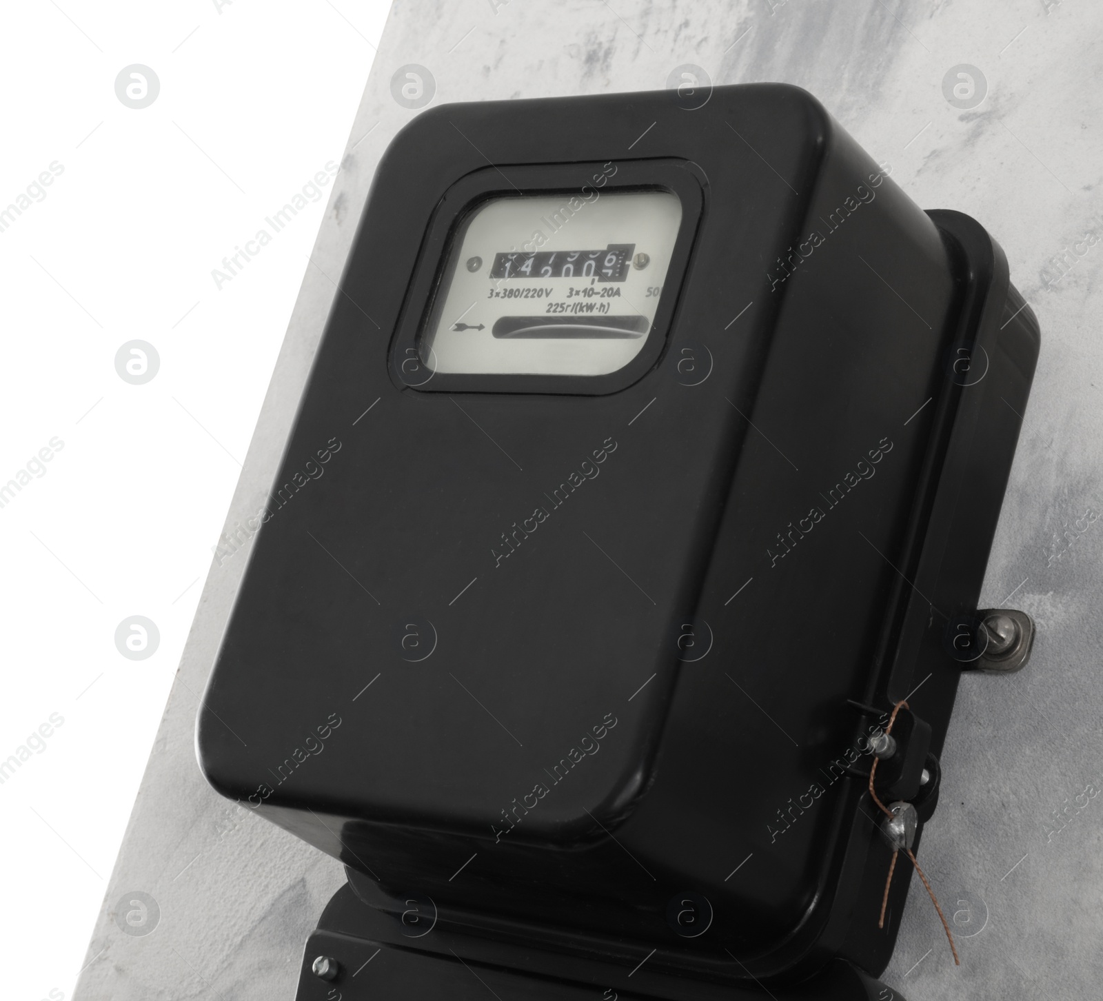 Photo of Electricity meter on light grey wall against white background. Space for text