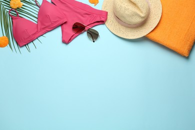 Flat lay composition with different beach objects on light blue background, space for text