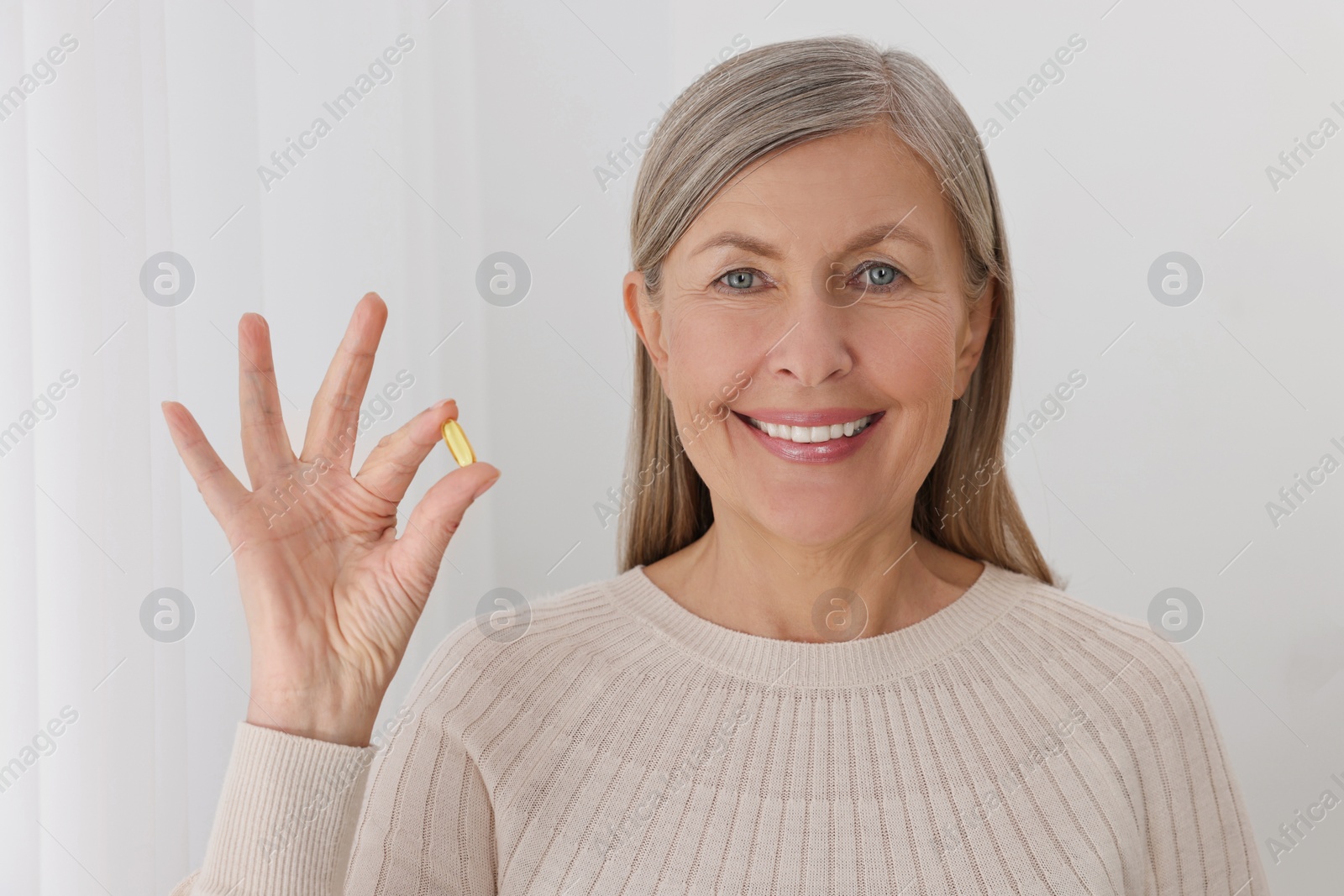 Photo of Beautiful woman with vitamin pill at home