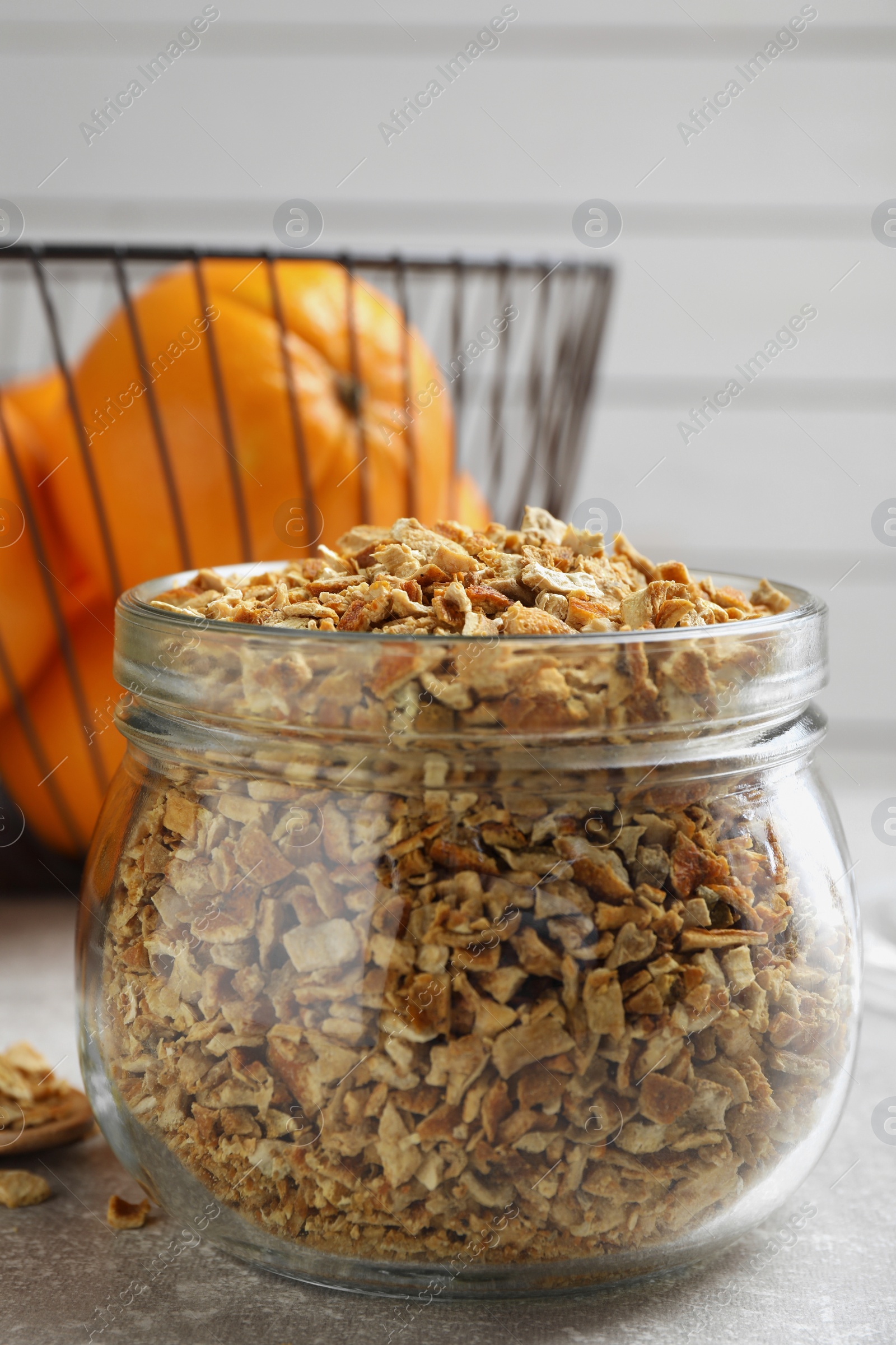 Photo of Jar of dried orange zest seasoning and fresh fruits on light grey table