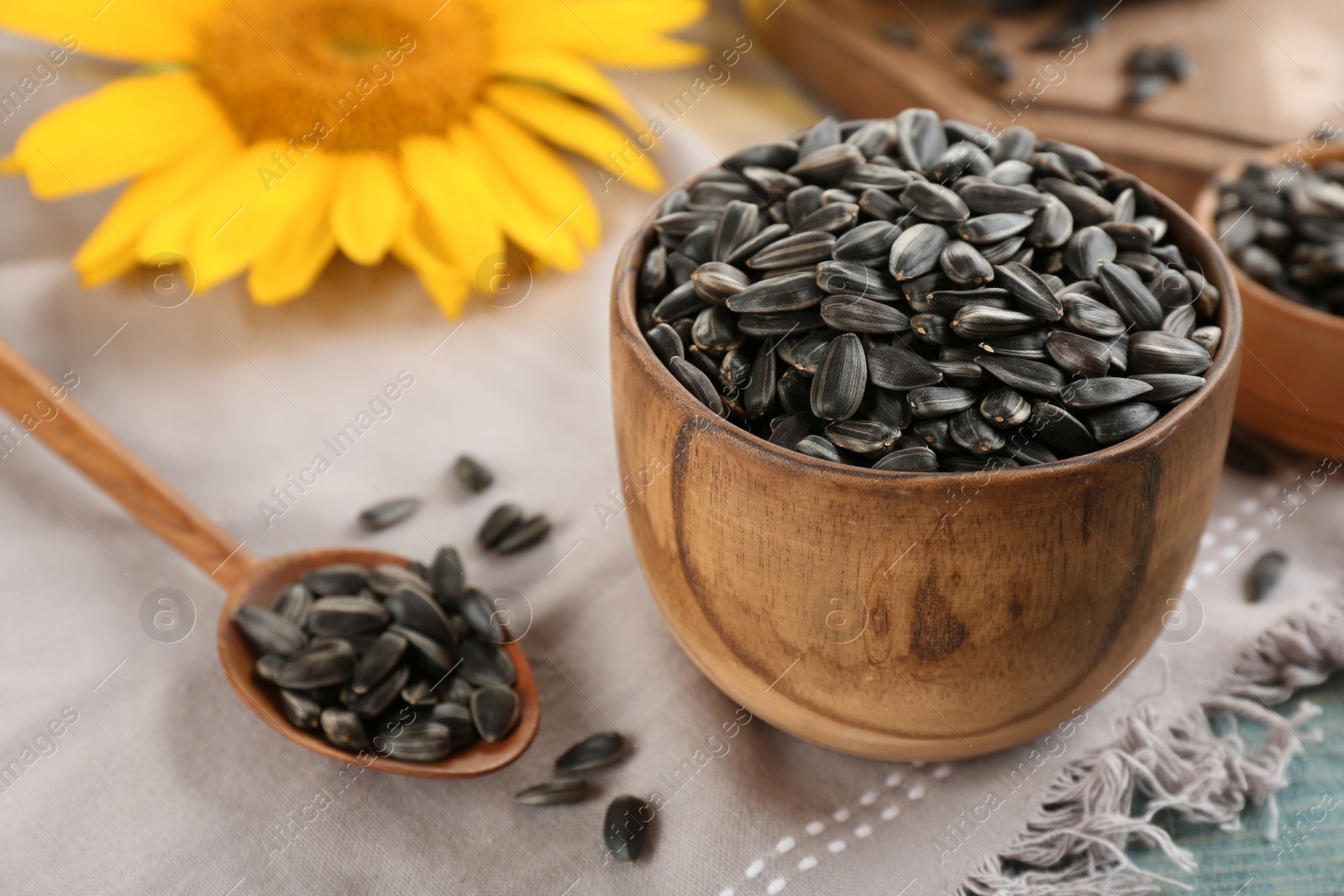 Photo of Bowl and spoon with sunflower seeds on table