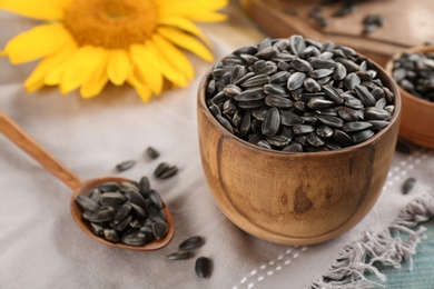 Photo of Bowl and spoon with sunflower seeds on table