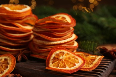 Photo of Dry orange slices and anise stars on wooden board, closeup. Bokeh effect