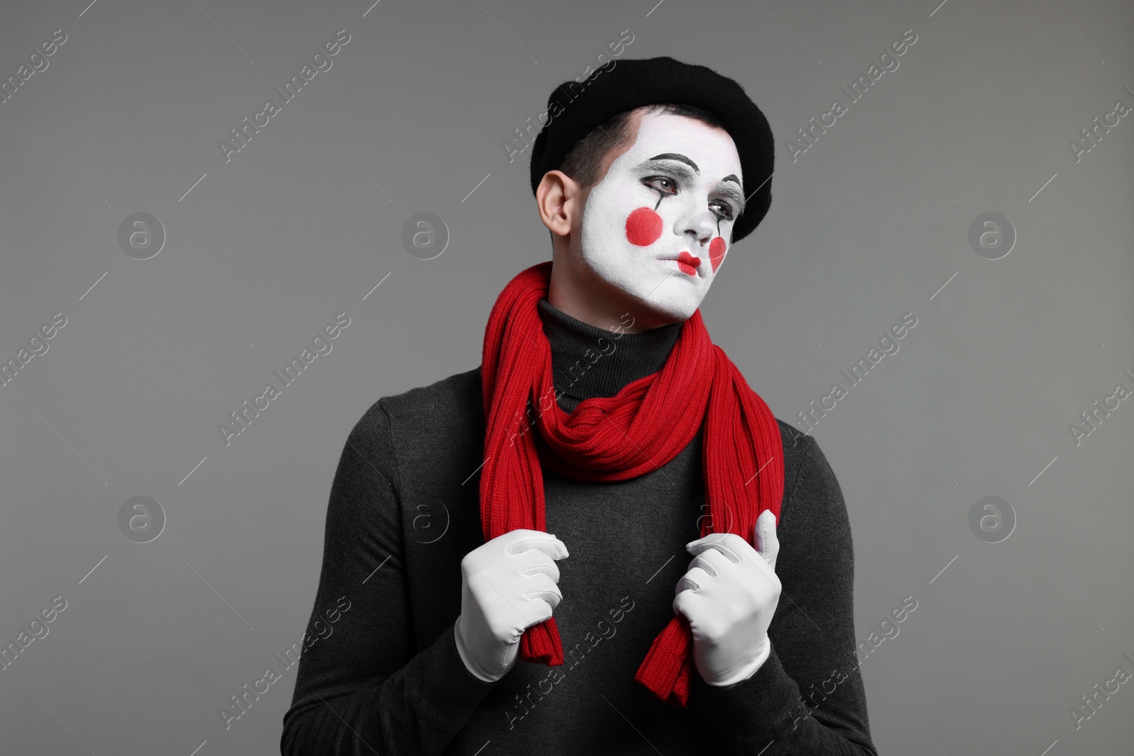 Photo of Portrait of mime artist in beret on grey background