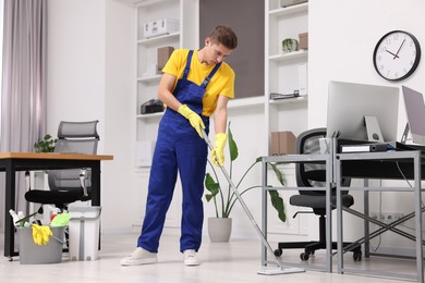 Cleaning service. Man washing floor with mop in office