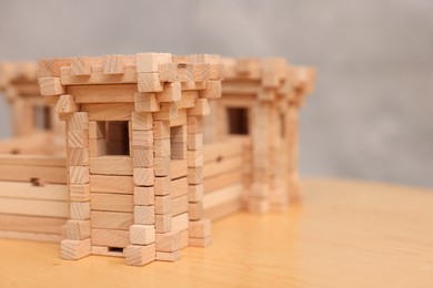 Photo of Children's toy. Wooden fortress on table against grey background, closeup. Space for text