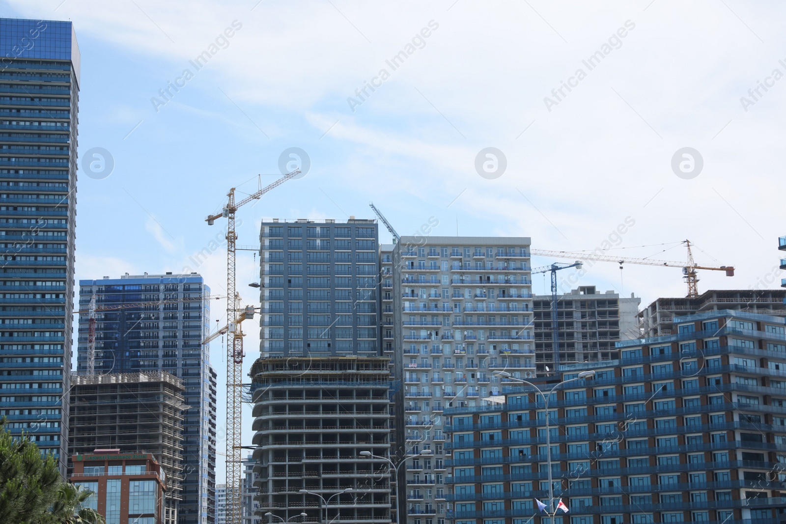 Photo of Batumi, Georgia - June 06, 2022: View of construction site with tower cranes near unfinished and modern buildings outdoors