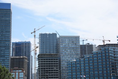 Batumi, Georgia - June 06, 2022: View of construction site with tower cranes near unfinished and modern buildings outdoors