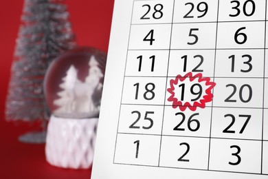 Photo of Saint Nicholas Day. Calendar with marked date December 19 and festive decor on red background, closeup