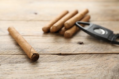 Photo of Cigar wrapped in tobacco leaf on wooden table. Space for text