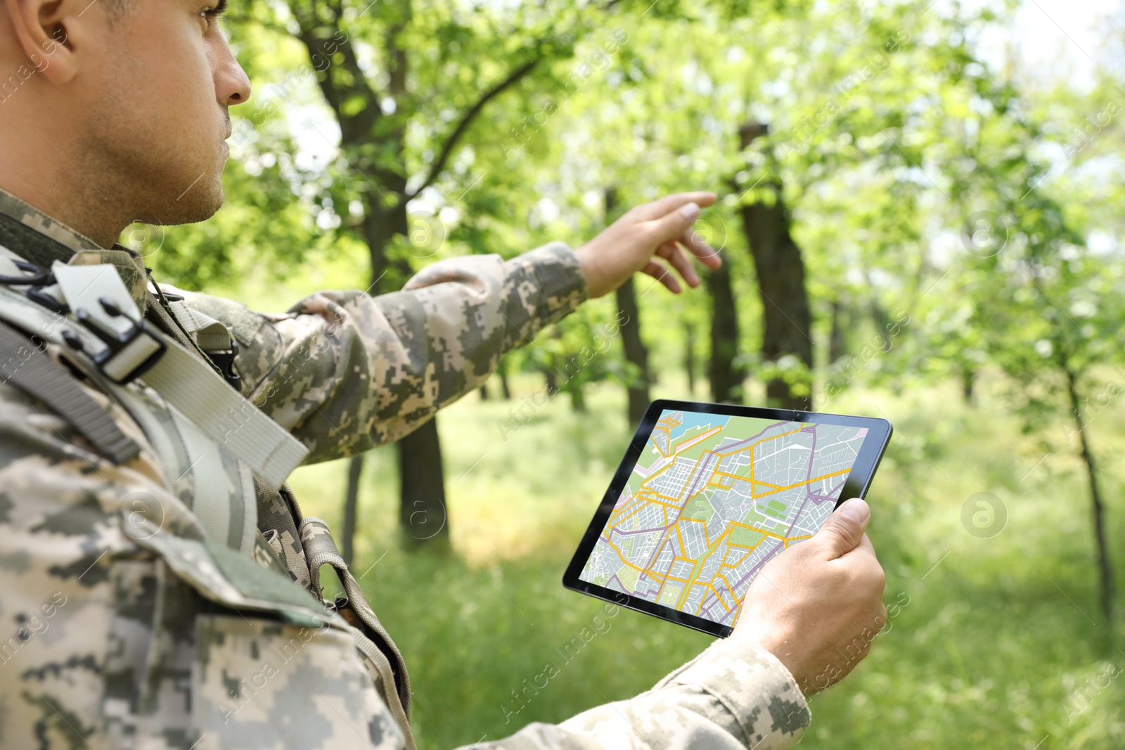 Photo of Soldier using tablet in forest. Modern technology