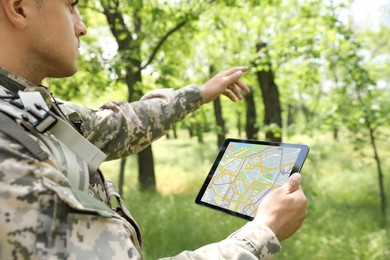 Soldier using tablet in forest. Modern technology