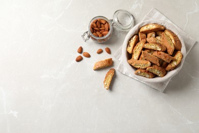 Photo of Traditional Italian almond biscuits (Cantucci) on light marble table, flat lay. Space for text
