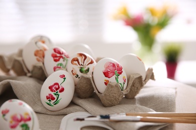 Photo of Beautifully painted Easter eggs on table indoors